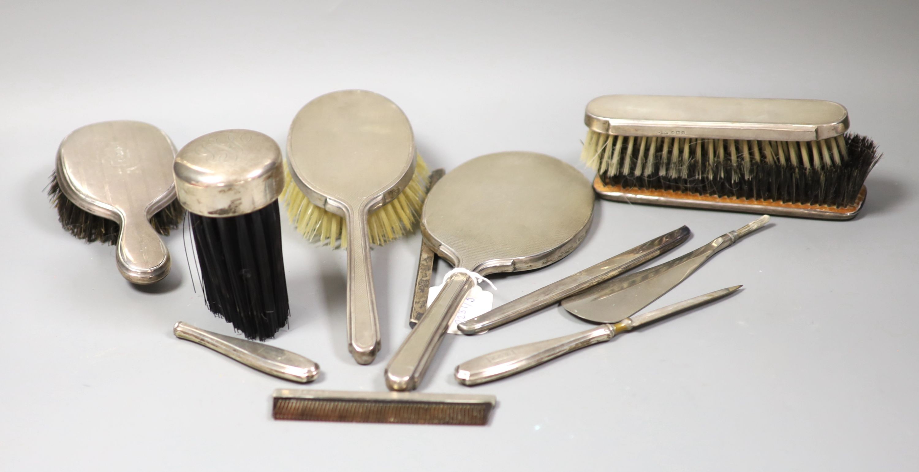 A 1940's silver mounted hand mirror and a group of other silver or sterling mounted brushes etc.